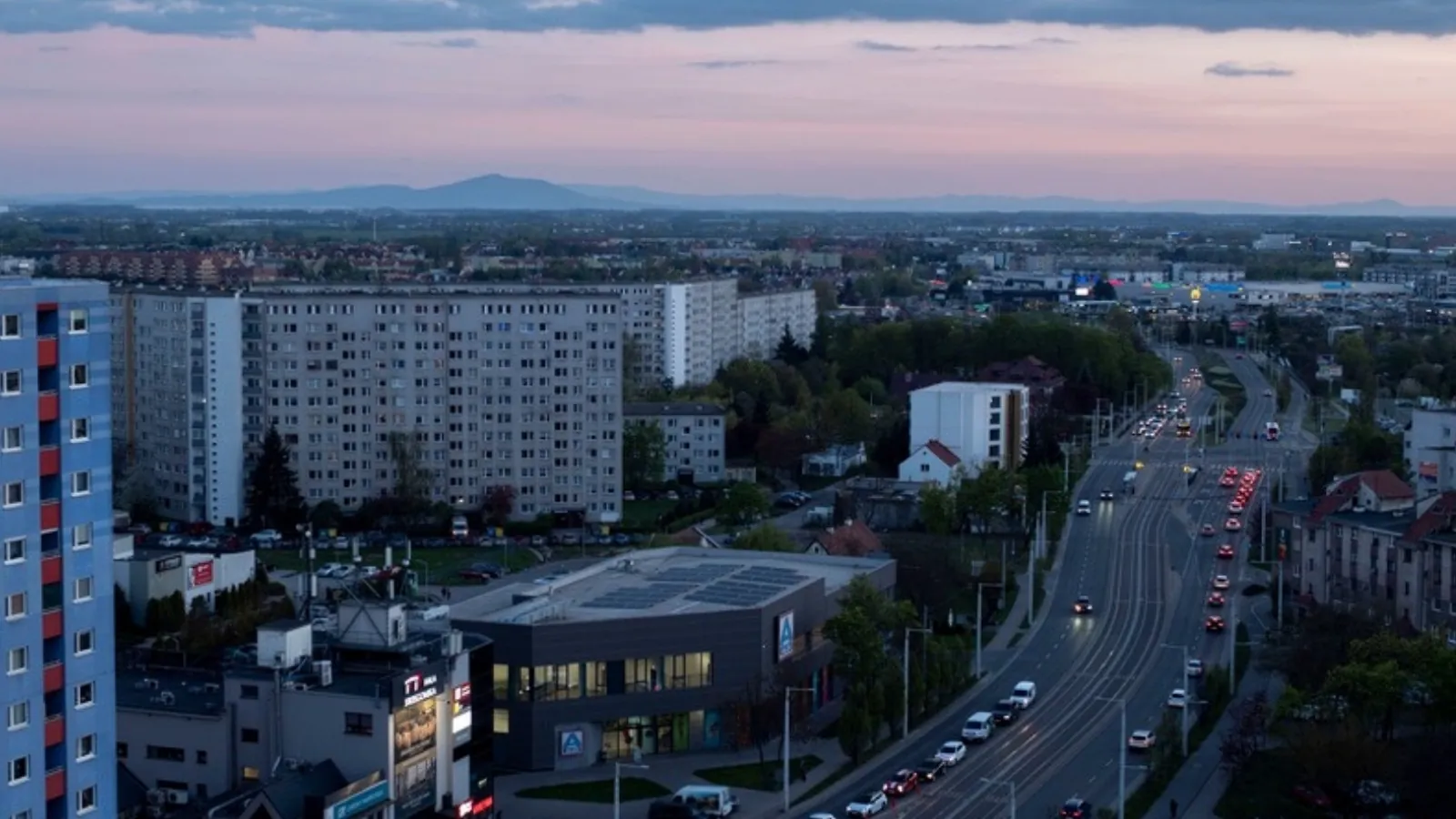 Blocuri de locuințe și un bulevard cu trafic la asfințit, în Wrocław, Polonia